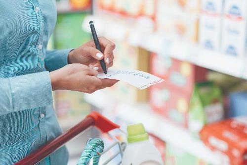 woman checking off shopping list while in the store