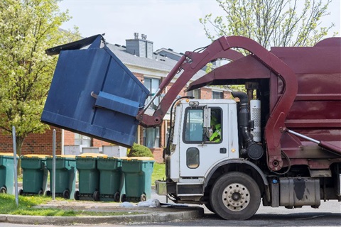 generic garbage truck picking up dumpster