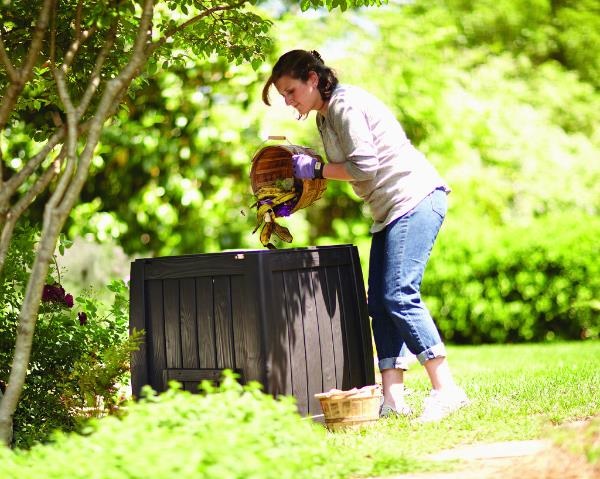 lady putting material into her backyard compost bin