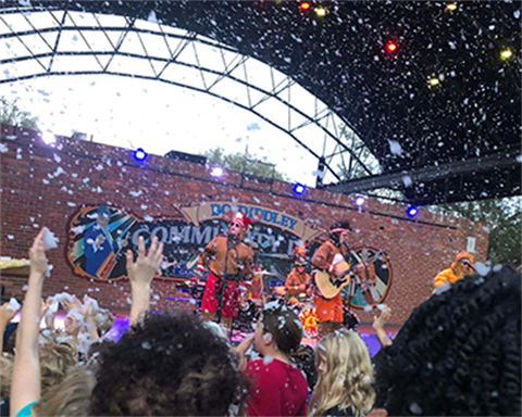 People dancing to band on stage at Bo Diddley Plaza