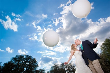Couple kiss while holding balloons