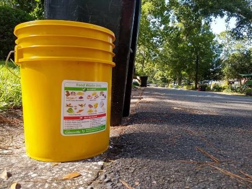 yellow food waste bucket set out curbside for collection
