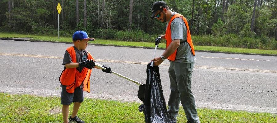 father and son picking up litter roadside