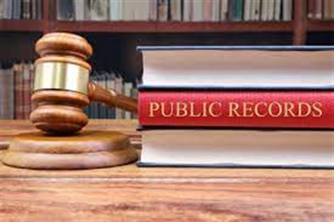 a gavel and public record book on desk